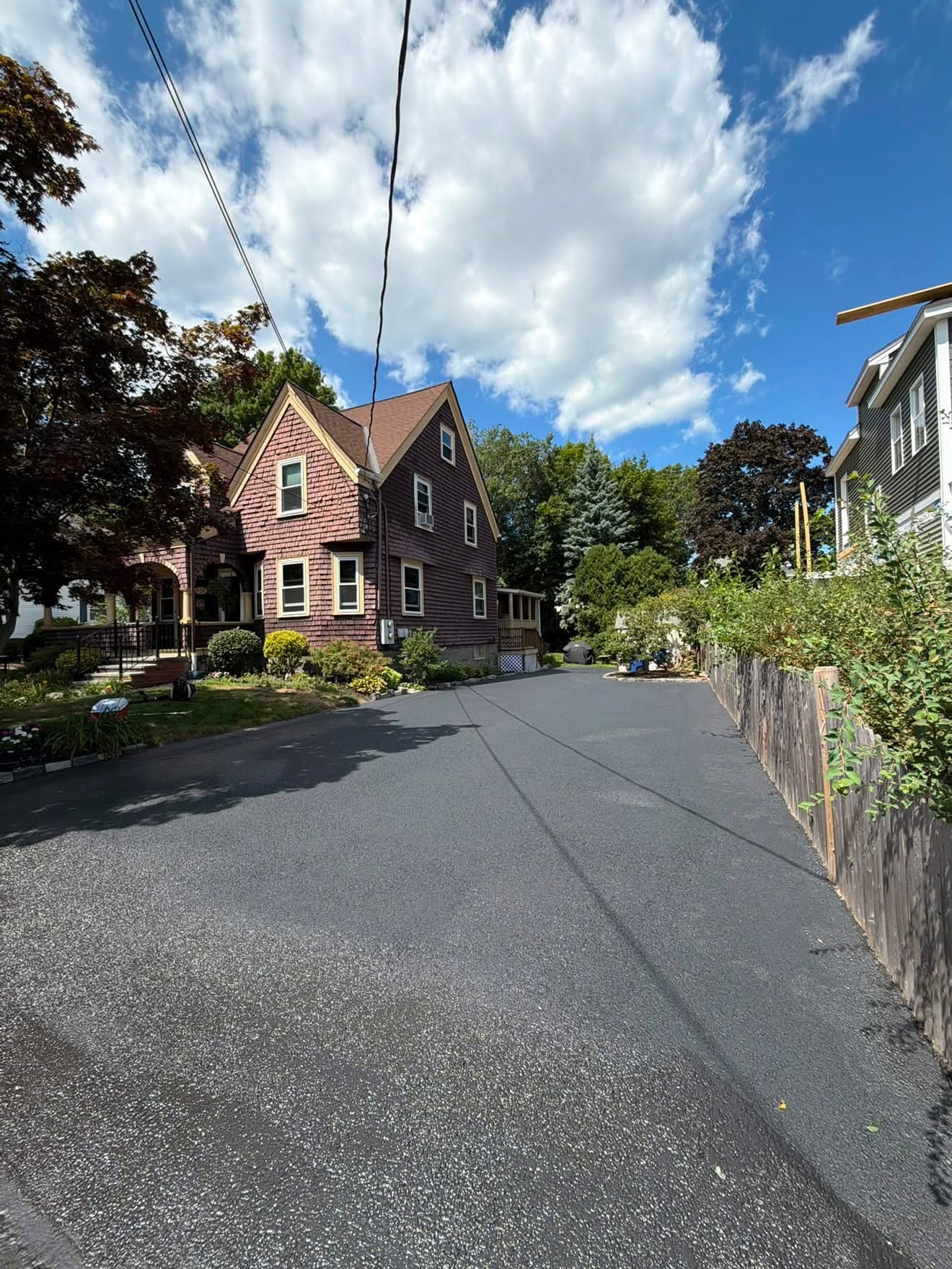 Narrow side driveway sealcoated between a house and garage