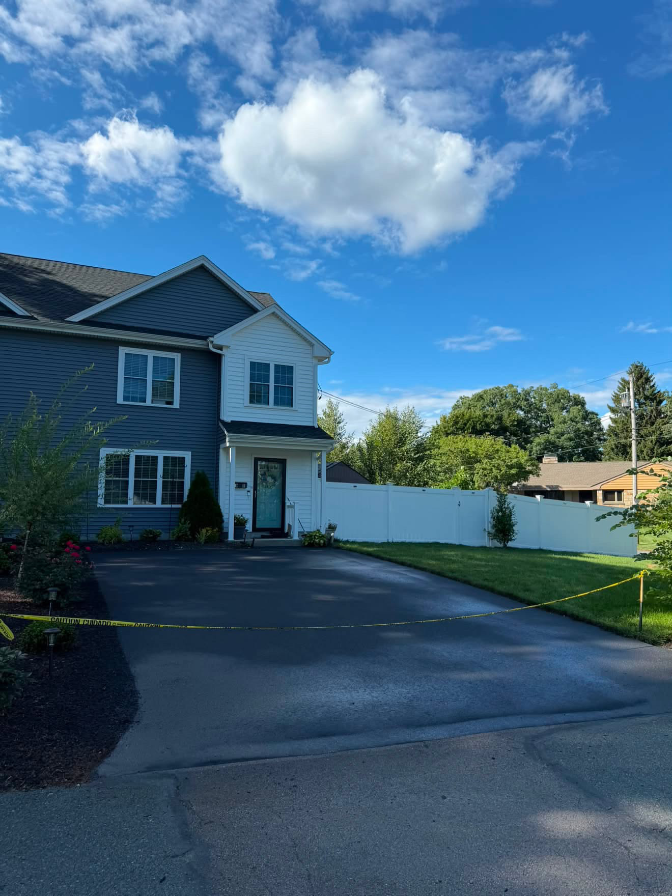 Shared driveway sealcoated between two homes on a tree-lined street